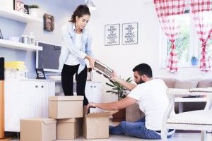 Portrait of a smiling couple packing boxes in a new house