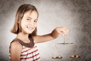 little girl holding justice scale