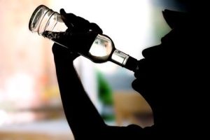 Silhouette of man drinking alcohol, close up