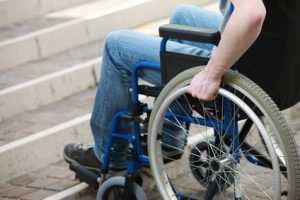 A young man in a wheelchair who can't get up the stairs