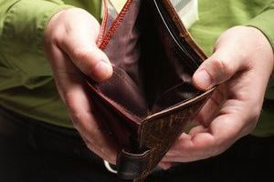 Poor economy represented by empty wallet in businessman's hands