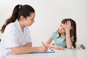 Female Doctor Comforting Depressed Patient Sitting At Table