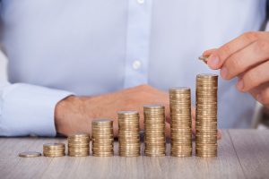 Midsection of businessman stacking euro coins at office desk