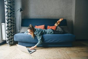 Girl working on laptop from home or student studying from home or freelancer. Or she is watching a video or using the Internet