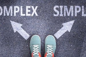 Complex and simple as different choices in life - pictured as words Complex, simple on a road to symbolize making decision and picking either Complex or simple as an option, 3d illustration